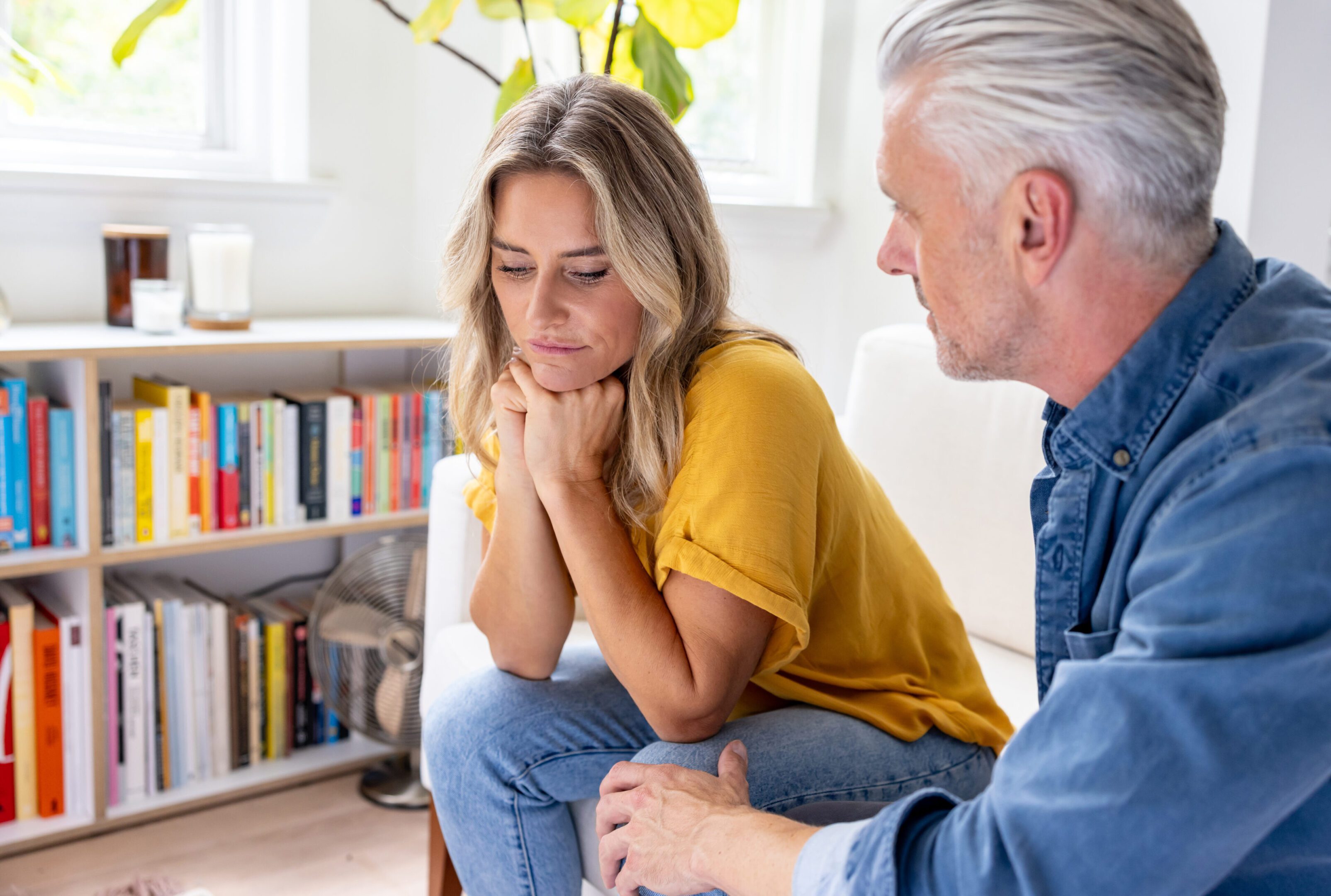 Two people engaged in a serious conversation indoors.