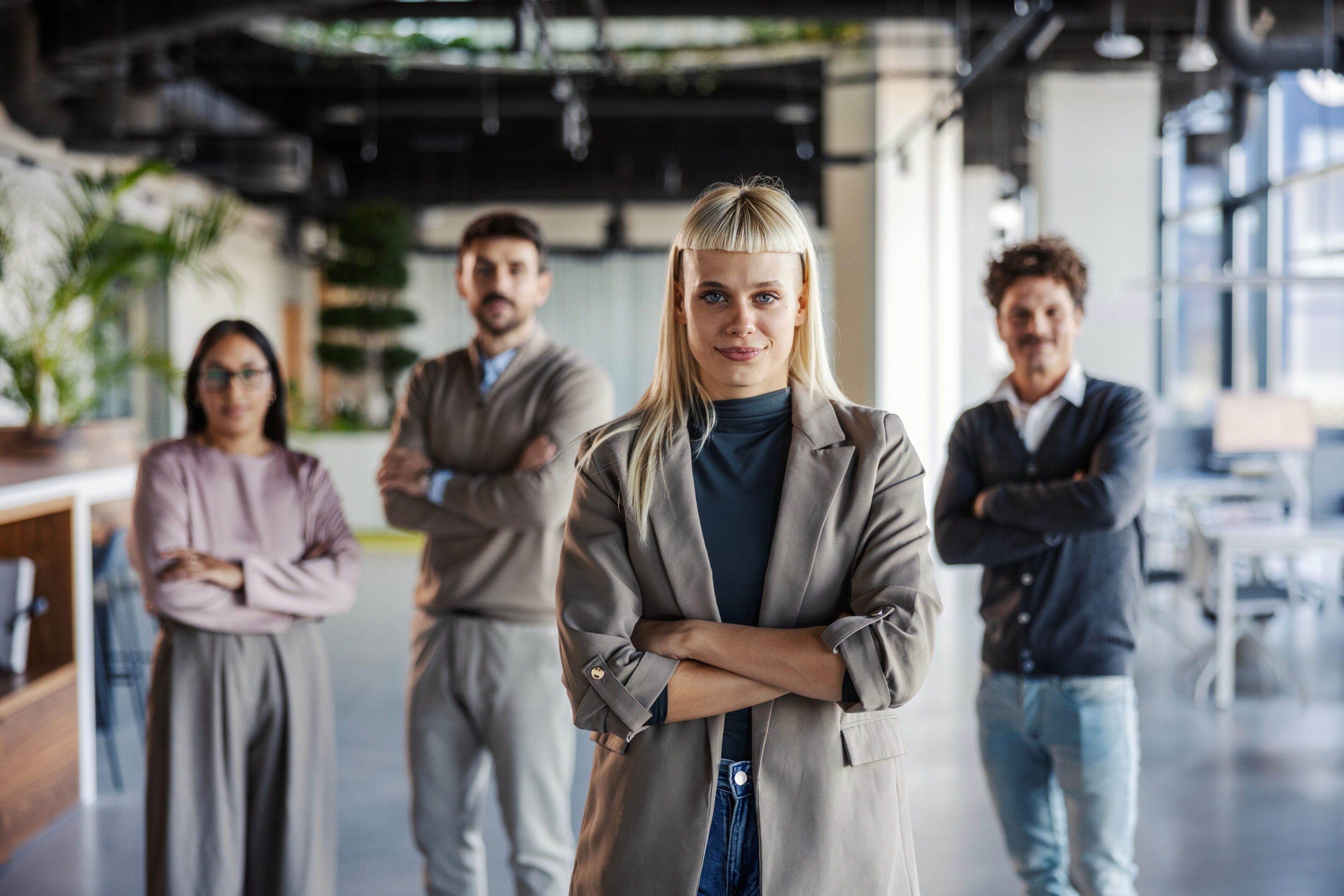 Confident businesswoman leading a diverse team in a modern office.