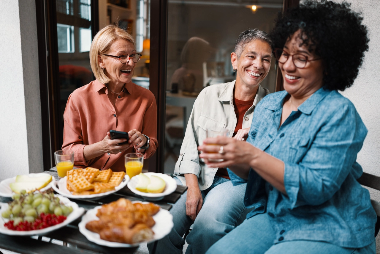 Friends laughing over brunch outdoors