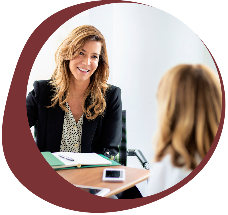 Two women engaged in a professional conversation in an office setting.